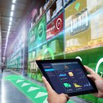 Smart Augmented Reality,AR warehouse management system. Worker hands holding tablet on blurred warehouse as background